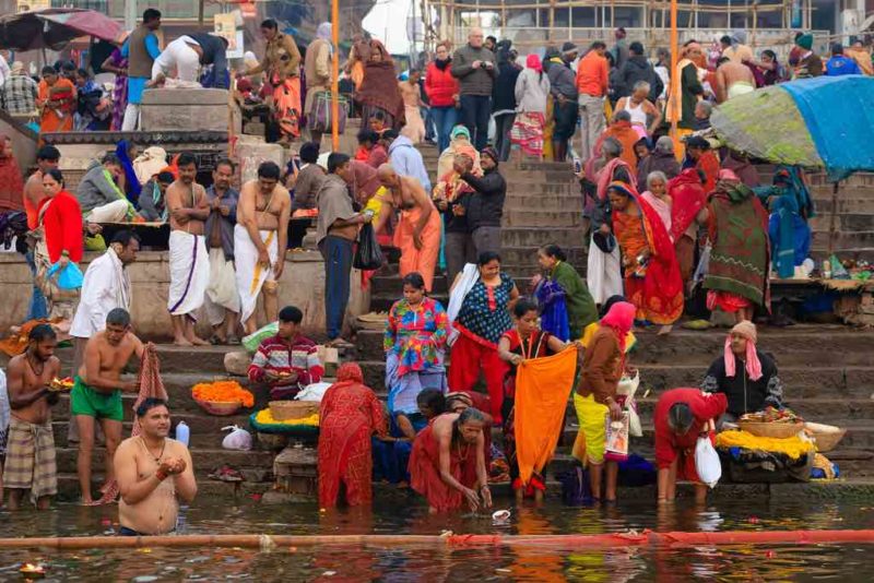 Das traditionelle Bad im Ganges und hinduistische Ritual bei Sonnenaufgang