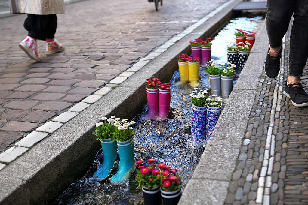 Gummistiefel im Wasser mit Blumen in der Stadt Freiburg. Touristenattraktion im Stadtzentrum